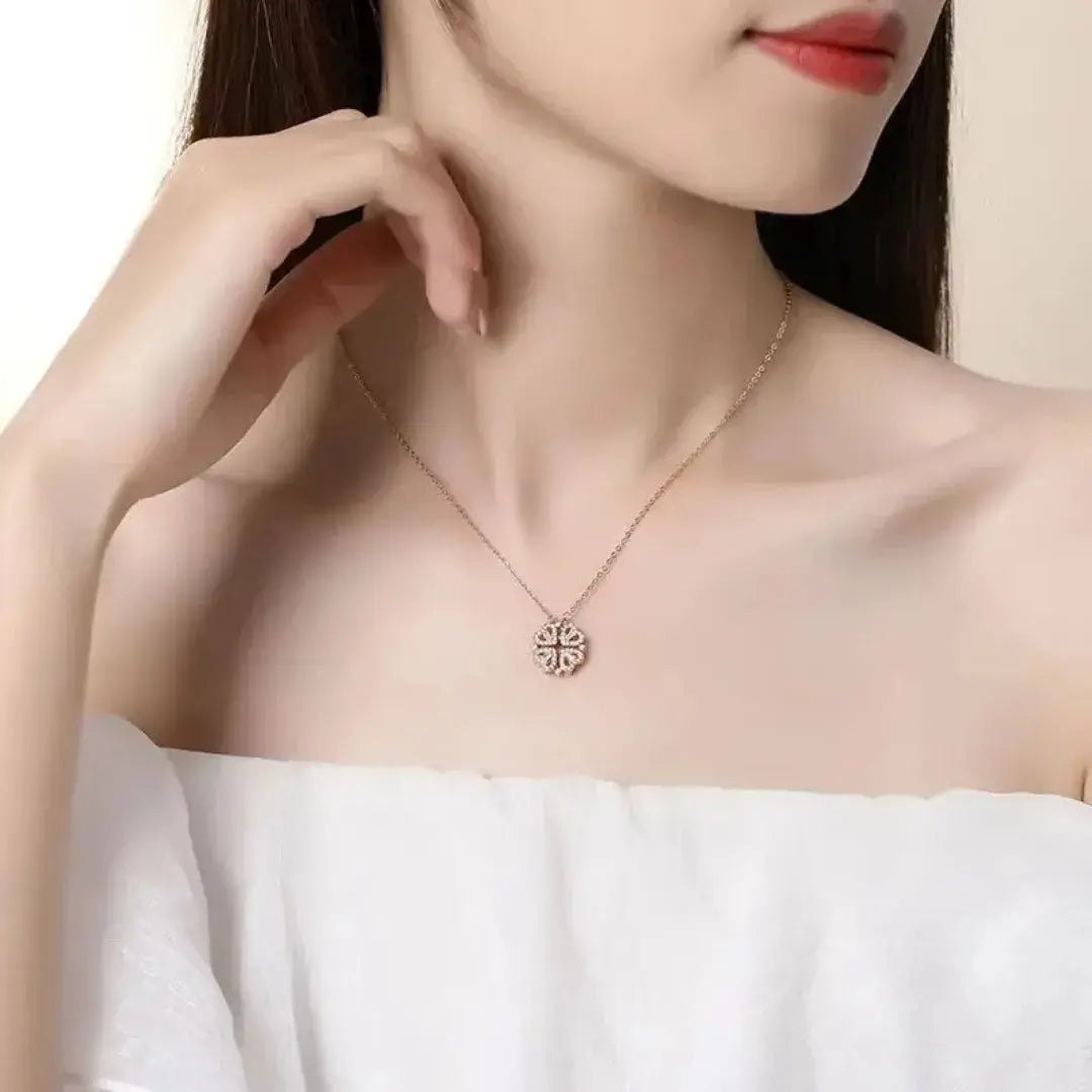 Colar dourado Romantizze com pingente de trevo de 4 folhas cravejado de zircônia, sobre fundo branco minimalista.