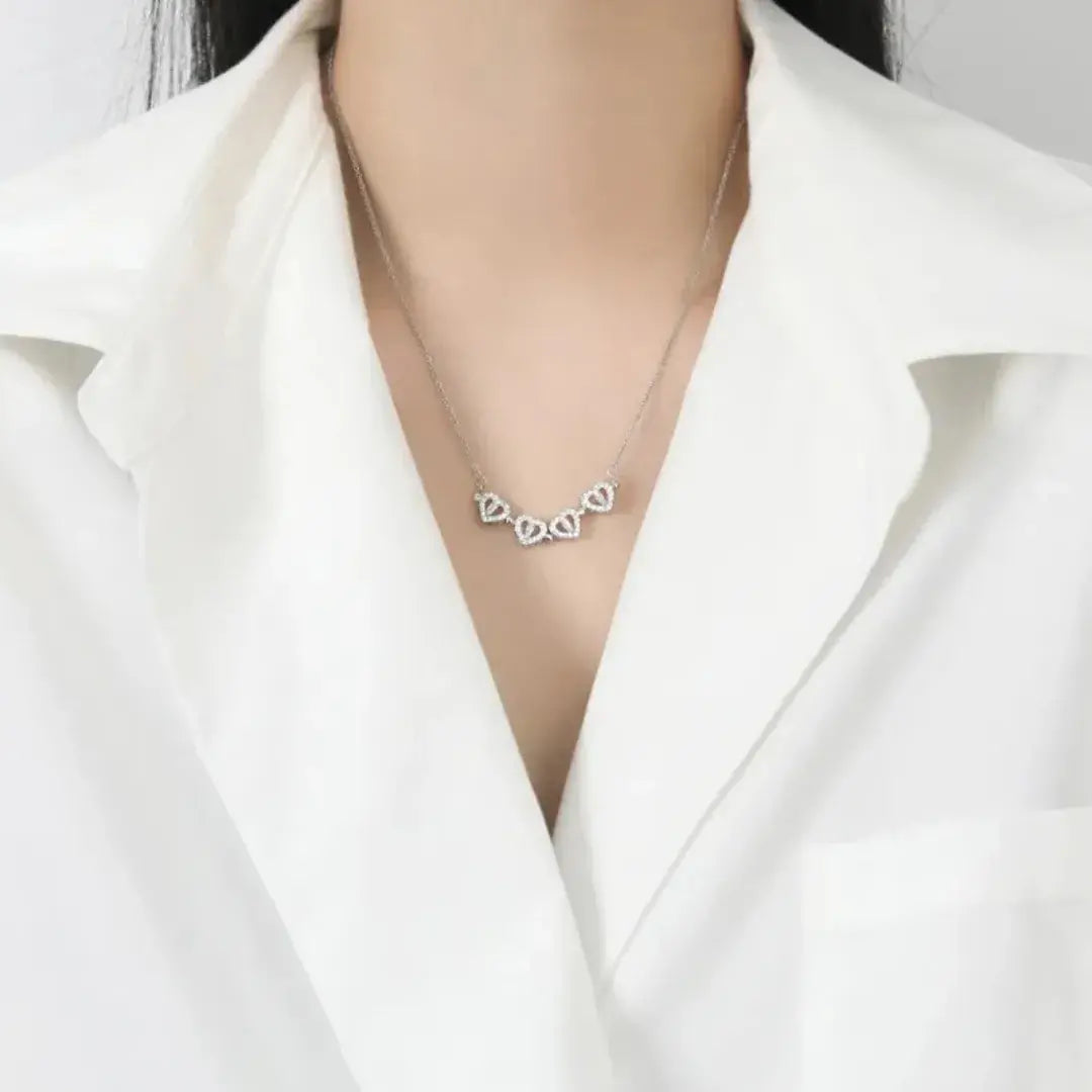 Modelo usando o colar Romantizze com pingente de trevo em prata e zircônias, em visual elegante com camisa branca.