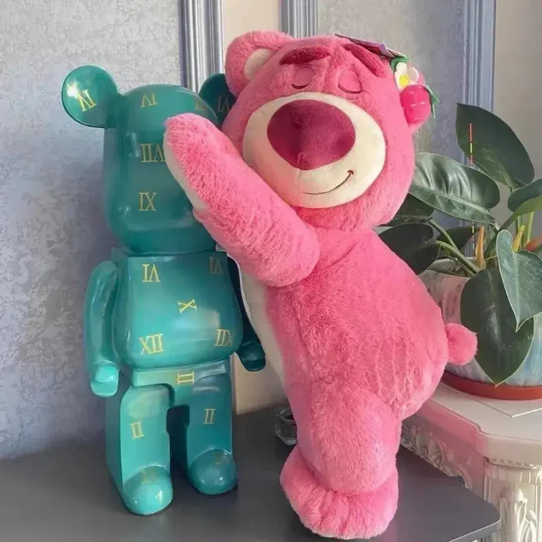 Urso rosa de pelúcia abraçando boneco azul – cena divertida e simbólica da Romantizze