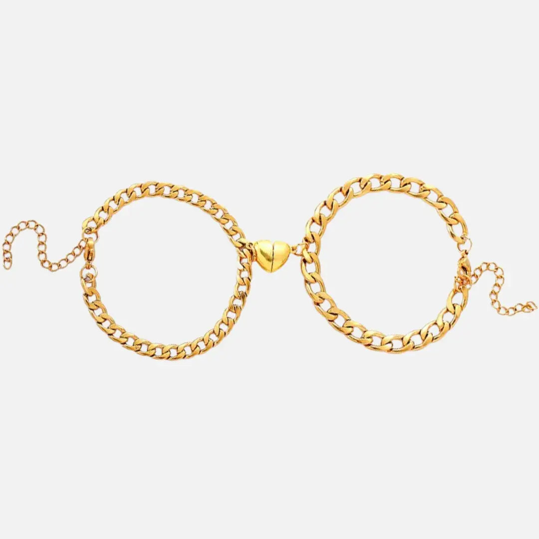 Par de pulseiras Romantizze magnéticas em tom dourado com pingente de coração, ideais para presentear casais.