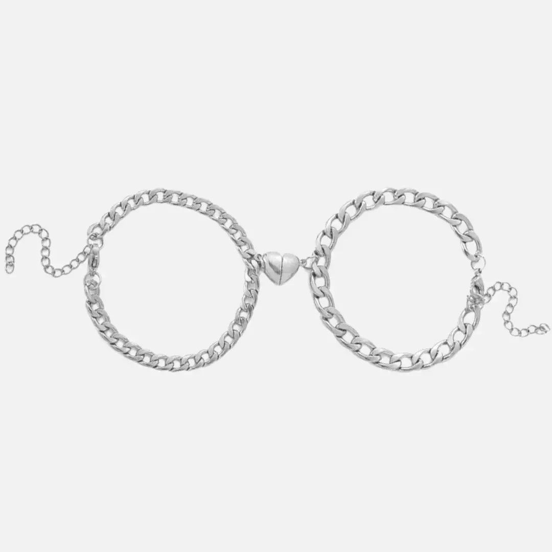 Par de pulseiras Romantizze magnéticas em prata com pingente de coração, design clássico e moderno para casais.