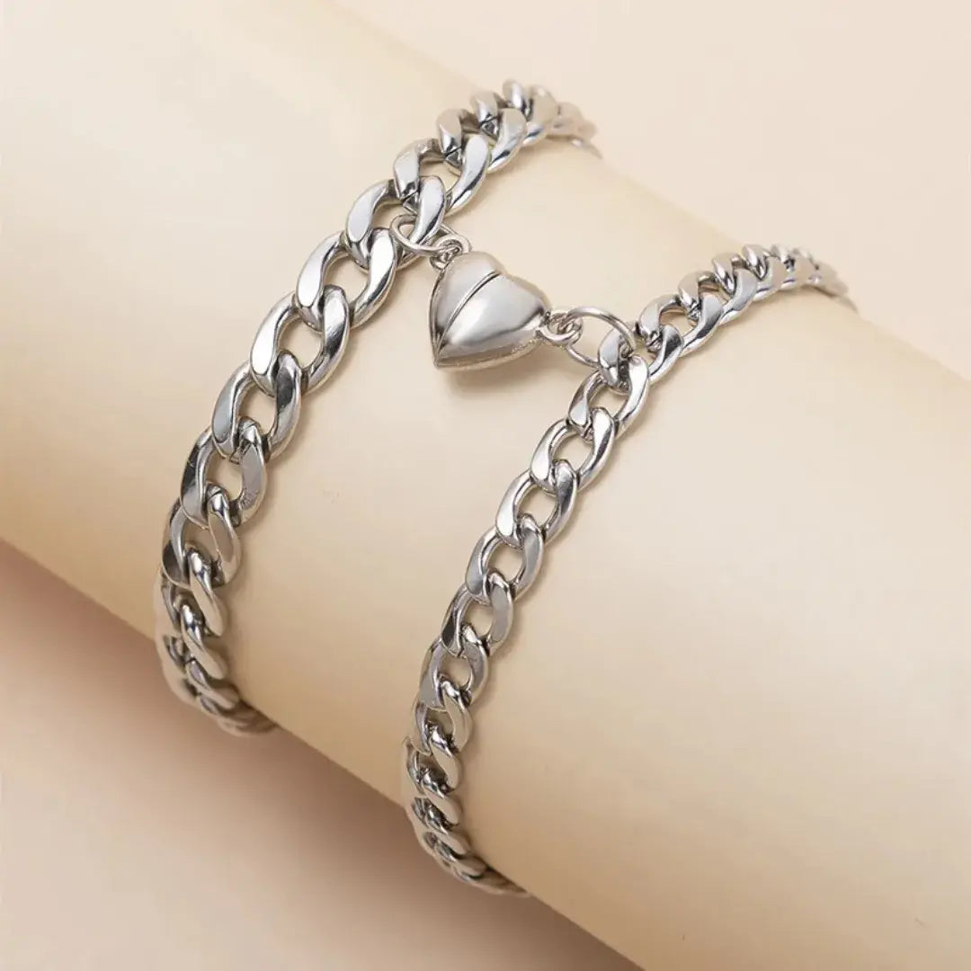 Pulseiras Romantizze magnéticas de aço inoxidável na cor prata sendo usadas no pulso, com pingente de coração.