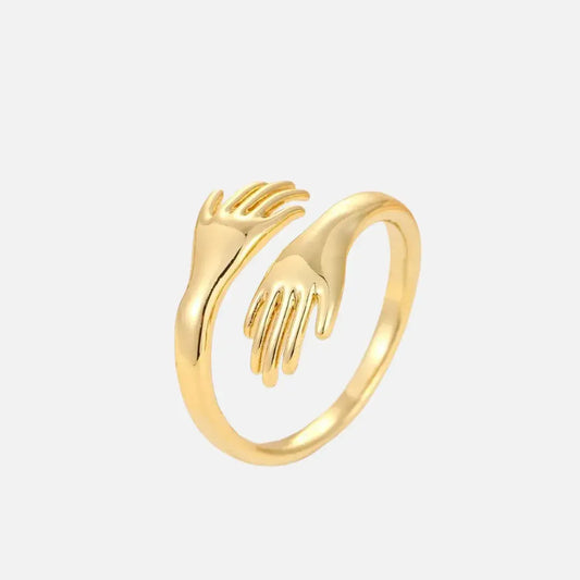 Anel feminino dourado com design de mãos entrelaçadas em formato de abraço – Romantizze