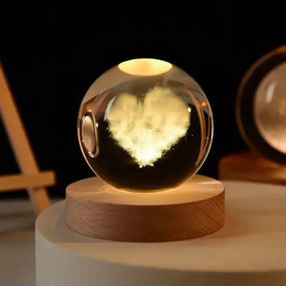 Luminária de cristal 3D com formato de coração iluminado em luz quente, sobre base de madeira – Romantizze
