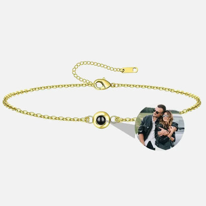 Pulseira dourada com pingente central de projeção exibindo foto personalizada de casal – Romantizze