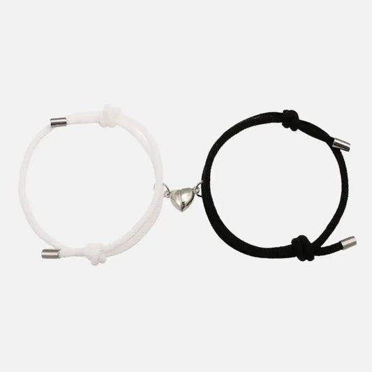 Pulseiras magnéticas Romantizze para casal nas cores preta e branca com fecho magnético em formato de coração.