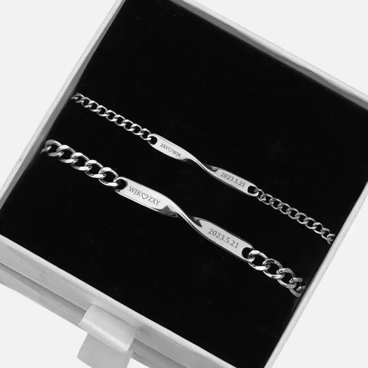 Conjunto de pulseiras Mobius personalizadas Romantizze com gravação de nome e data, em aço prateado, apresentadas em caixa preta.